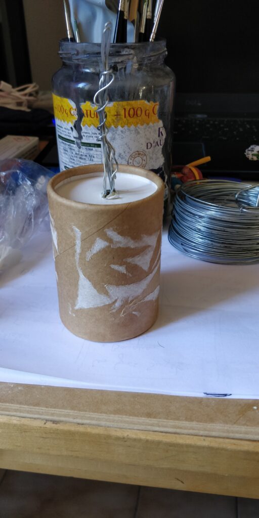 le fil de fer et le bouchon fixés sur une boîte de thé cylindrique